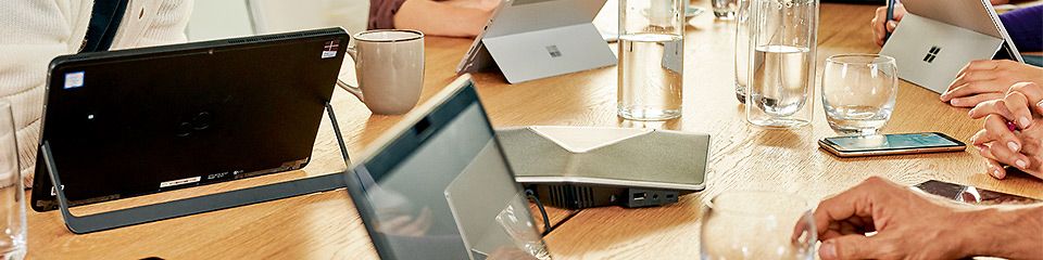 Data Intelligence Hub: An einem großen Tisch sitzen Personen und vor ihnen stehen verschiedene Tablet-PC und Laptops