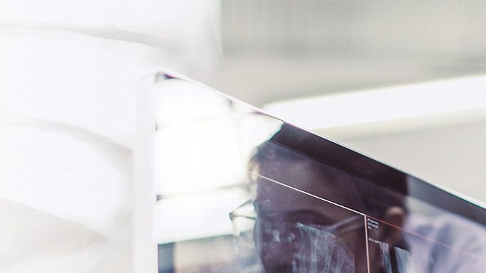 Lösung Digitalisierung Gesundheitswesen: Eine Frau und ein Mann in Arztkleidung betrachten Röntgenaufnahmen auf einem Bildschirm