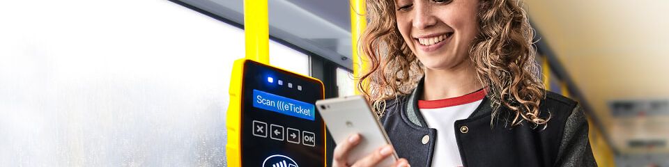 Lachende Frau im Bus scannt mit Handy ein VDV (((eTicket als Fahrschein