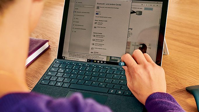 Eine Frau bedient auf eiem Laptop eine digitale Verwaltung Software mit ihrem Stift
