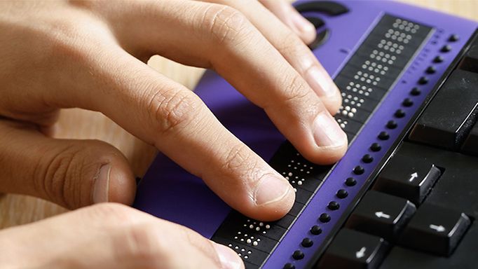 Digitale Barrierefreiheit Behörden: Finger bedienen Braille-Tastatur zur Eingabe von Punktschrift