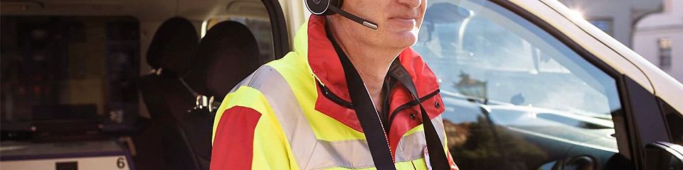 Digitale Rettungswagen Ausstattung: Ein ärztlicher Notfallhelfer steht mit einem Tablet vor seinem Einsatzfahrzeug