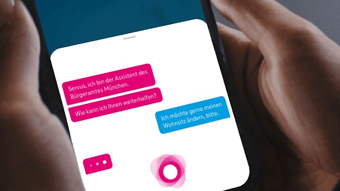Zwei Frauenhände halten ein Smartphone, auf dem das Textlog einer Sprachassistenz-App läuft