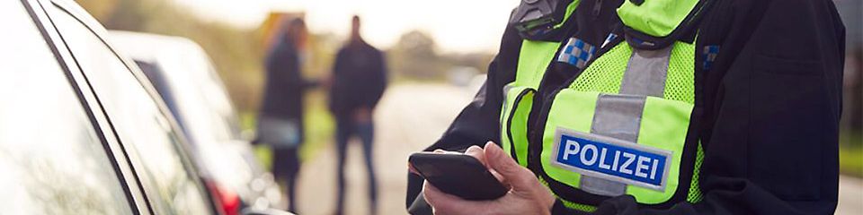 Polizistin der Landespolizei Brandenburg hält Smartphone in der Hand