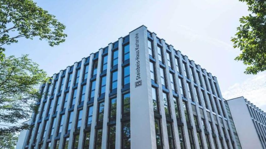 Ein Traktor mit Anhänger fährt auf einem Strohfeld