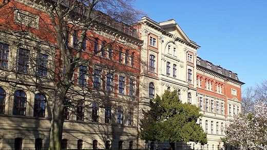 Frontansicht des historischen Gebaeudes am Campus Koethen mit Wiese und Baeumen