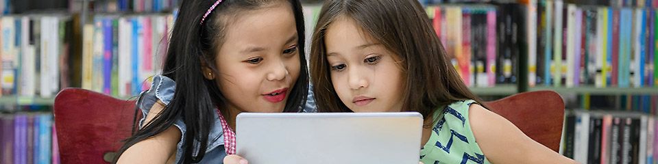 Hardware für die digitale Schule - Zwei Schülerinnen schauen auf ein Tablet