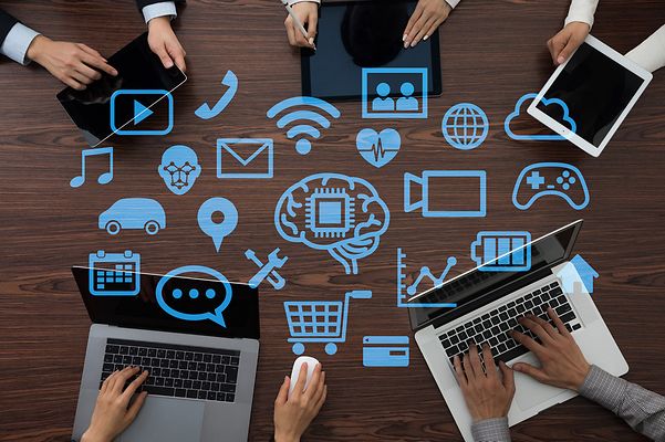 Menschen an Laptops, umgeben von digitalen Symbolen nutzen Open Source Collaboration