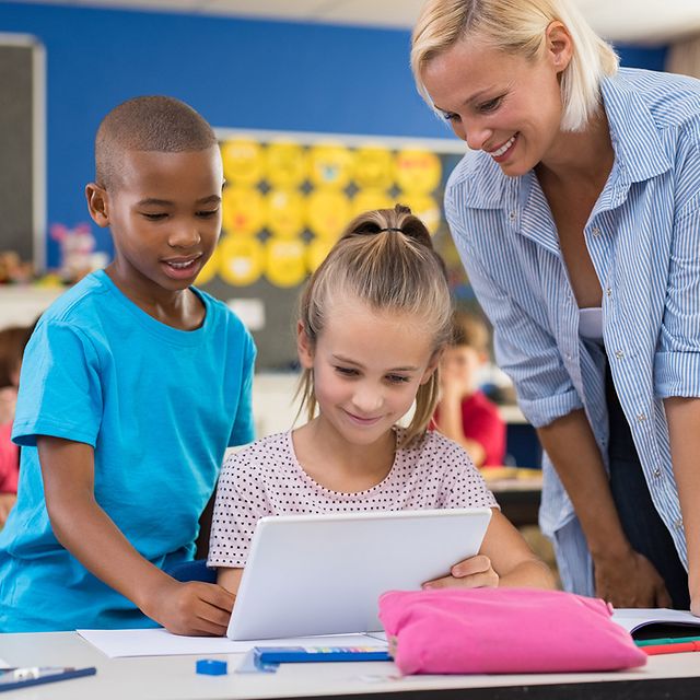 Schülerin und Schüler sitzt am Tablet im Klassenzimmer und lernen.