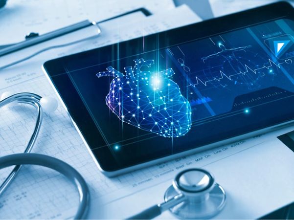 Tablet mit digitaler Herzgrafik liegt neben Stethoskop und medizinischen Unterlagen.