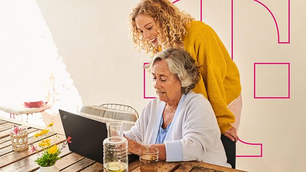 Zwei Personen sitzen an einem Tisch und nutzen gemeinsam einen Laptop