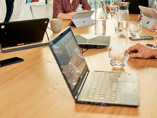 Telekom-Mitarbeiterin berät Kundin oder Kunde via Telefonat am Computer.