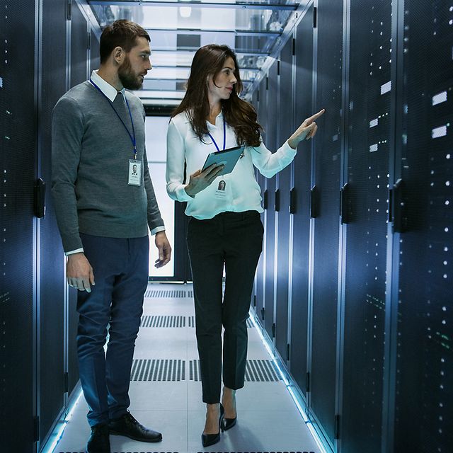 Ein Mann im Anzug tippt mit dem Finger auf ein Gitternetz auf dem Digital Transformation steht