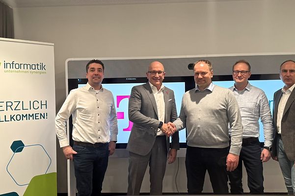 Fünf Männer stehen bei gkv informatik und Telekom zusammen.