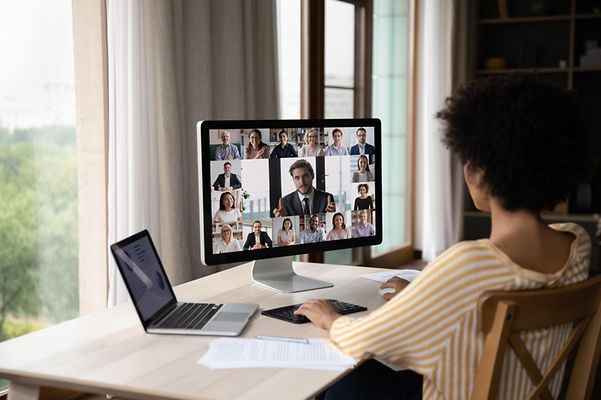 Frau sitzt am Schreibtisch und füht Videokonferenz durch mit Open Source Collabortation