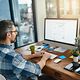 Person sitzt am Schreibtisch am Computer und nutzt Open-Source Collaboration Plattform