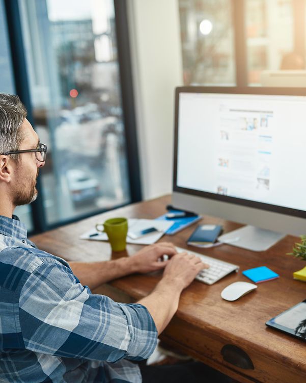 Person sitzt am Schreibtisch am Computer und nutzt Open-Source Collaboration Plattform