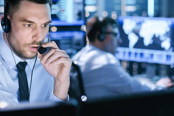 Person sitzt in Einsatzzentrale und nutzte AlarmRuf der Telekom