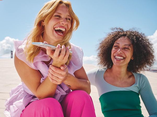 Person telefoniert lächelnd mit ihrem Smartphone