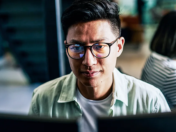 Person arbeitet fokussiert am Laptop