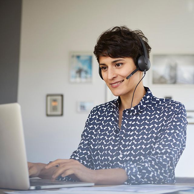 Telekom-Mitarbeiterin berät Kundin oder Kunde via Telefonat am Computer.