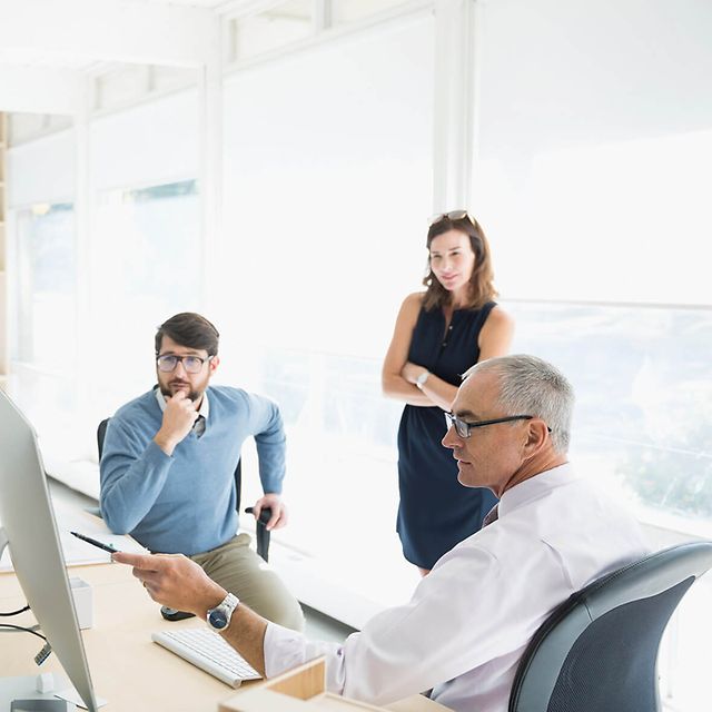 Several people are having a discussion in a bright office or meeting room