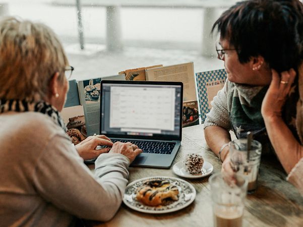 Two people are working together on a laptop at a table