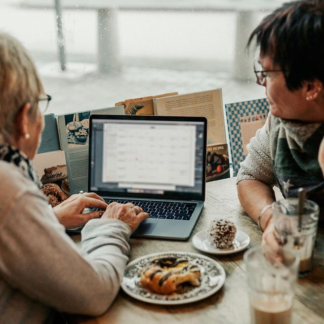 Two people are working together on a laptop at the table