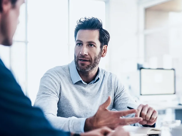 Two people talking at a desk in the office