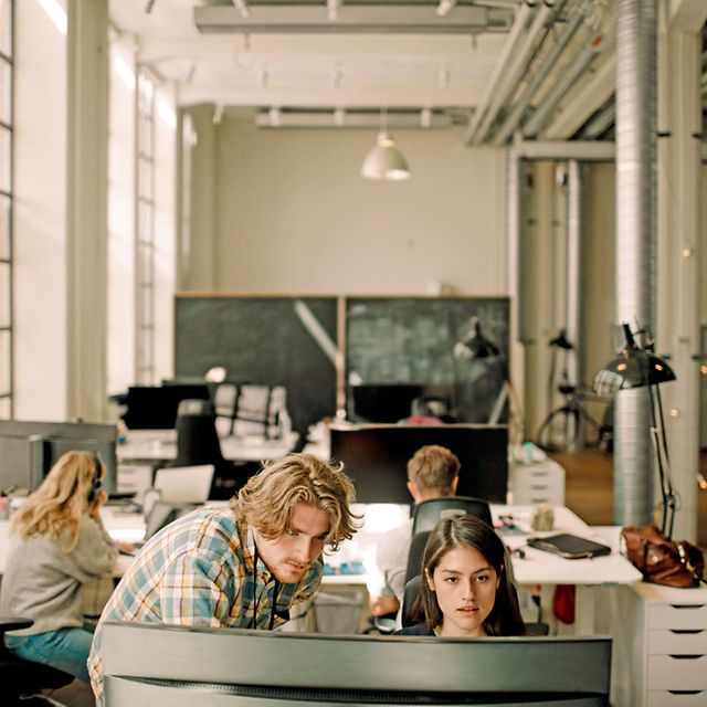 Several people work together in the office, connected via a network linking different locations