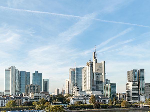 A view of Frankfurt with its modern skyline and high-rise buildings against a clear sky.