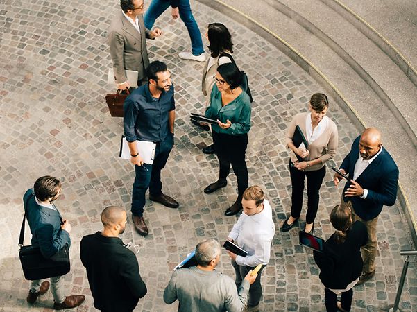 A bird’s-eye view of a group of people chatting outside.