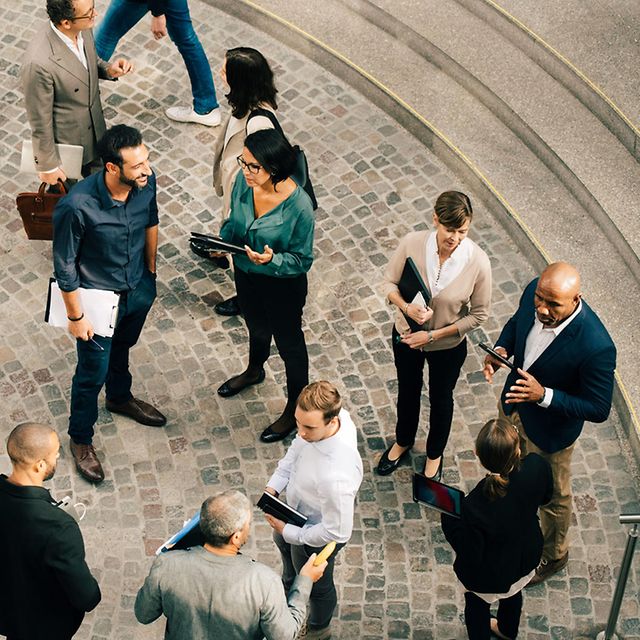 Several people are standing in a square, chatting during a trade fair