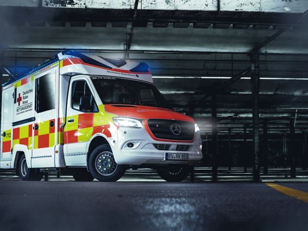 A German Red Cross ambulance is on standby in a vehicle depot.