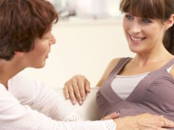 A pregnant person receives advice and support from another person.