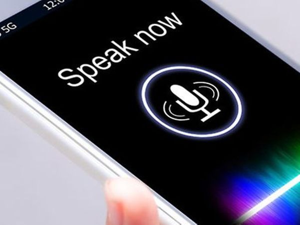 A smartphone with voice control enabled and a microphone icon on the screen.
