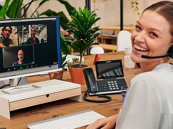 A woman laughs at the camera during a video conference.