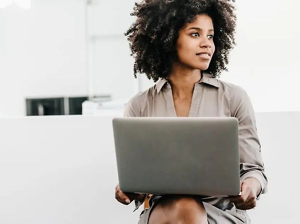 A woman is working on her laptop and using Telekom’s Industrial AI Cloud